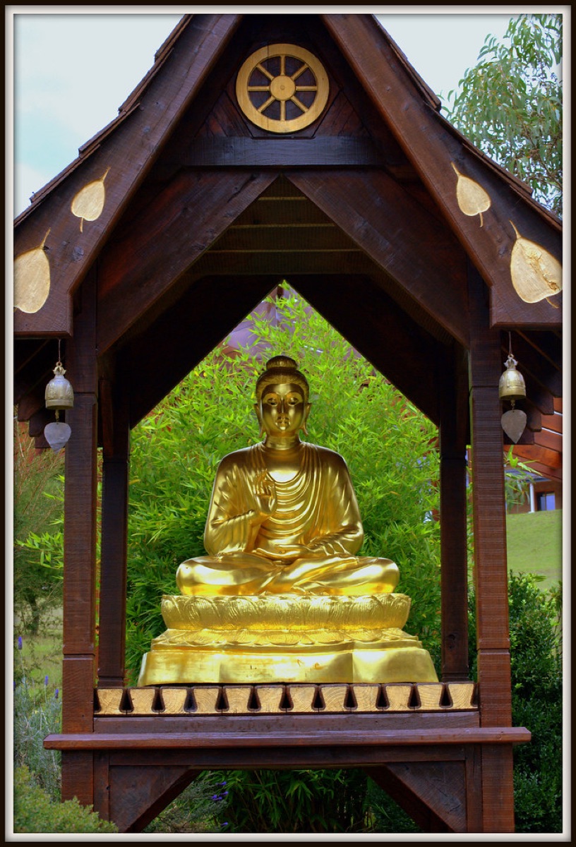 Golden Buddha statue in a wooden shrine