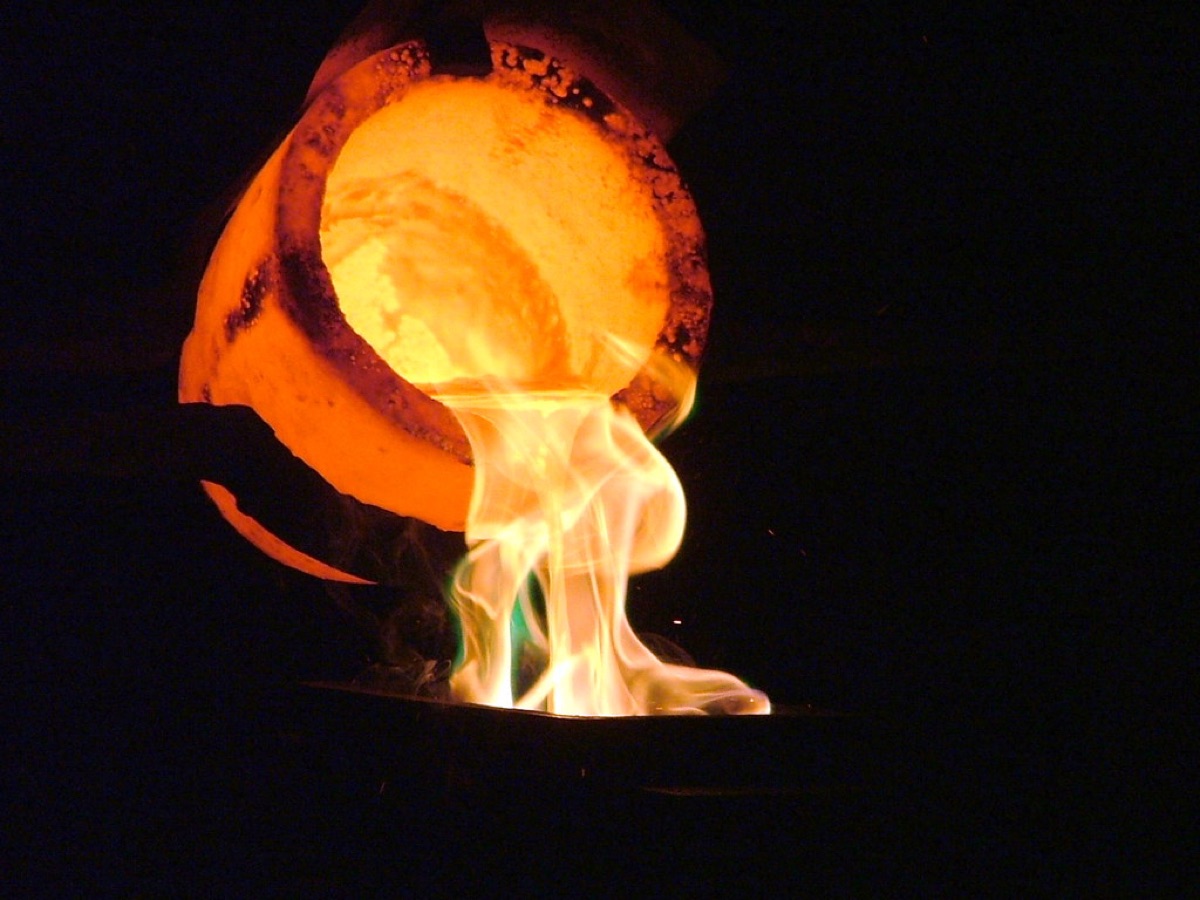 Molten gold pouring from a glowing crucible